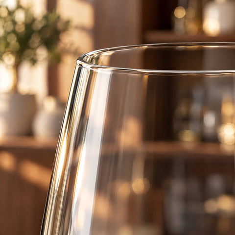 Gros plan en contre-jour sur le buvant du verre de dégustation Solfège, bord fin et paroi resserrée sur fond blanc