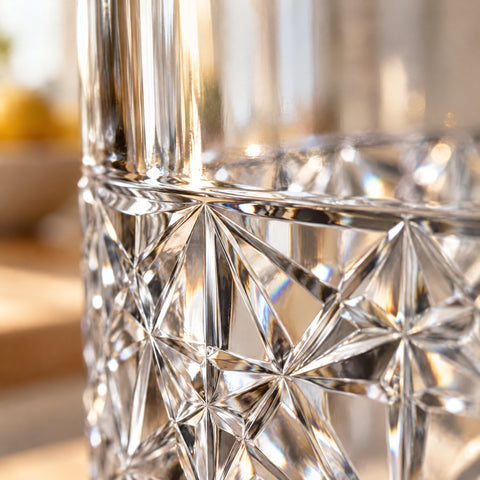 Bandeau taillé d'étoiles et triangles du verre à whisky Constellation en gros plan, rainures mates en lumière rasante