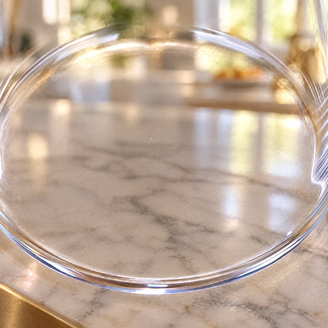 Gros plan sur la base épaisse du verre tube Calame, anneaux concentriques et paroi fine, flou lumineux d'une cuisine claire