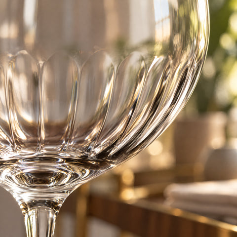 Gros plan sur les côtes optiques du bas du calice du verre à vin Vibrato, cannelures verticales s'estompant vers le haut