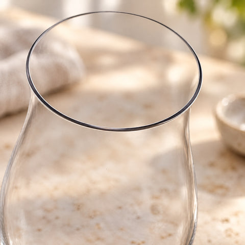 Gros plan sur le buvant fin du verre tulipe de dégustation Pistil vu légèrement de dessus, fond flou de cuisine