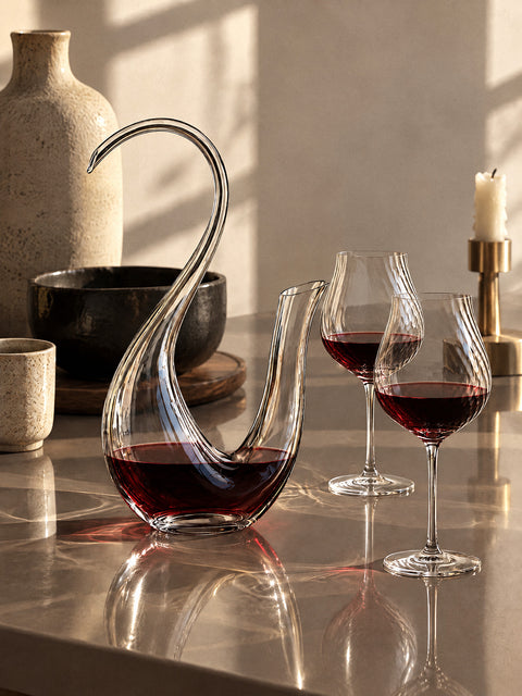 Carafe à décanter en cristal Vinique et verres à vin tulipe en cristal servis de vin rouge sur une table laquée