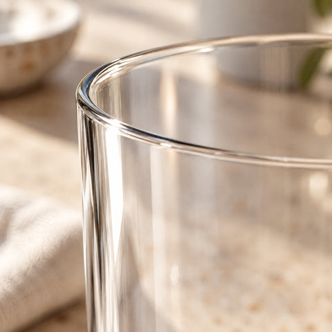 Gros plan du buvant fin et sans bourrelet du grand verre à café Margelle, en contre-jour sur fond blanc