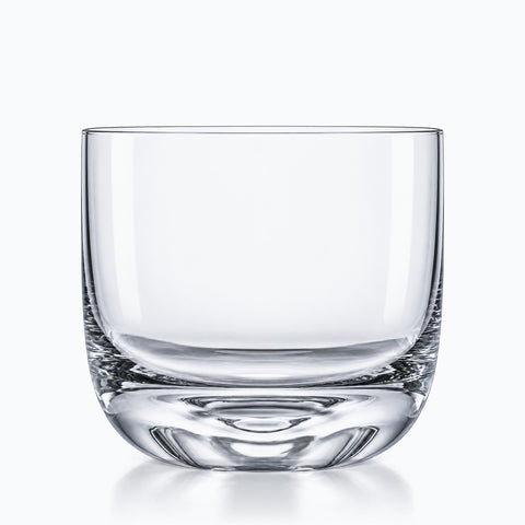 Verre à whisky fond arrondi en verre cristallin transparent, bas bombé sur une petite assise plate, vu de face sur fond blanc.