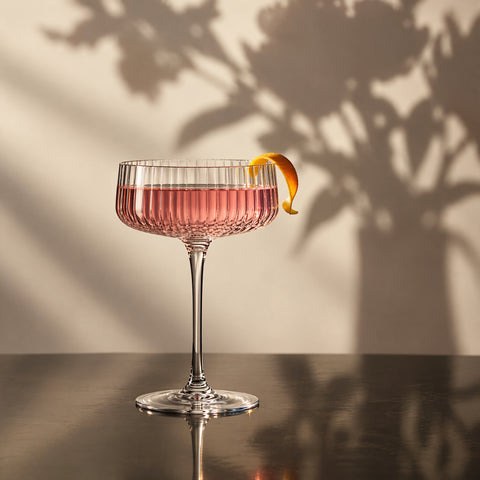 Verre coupe à cocktail Pivoine servi d'un cocktail rose, en studio